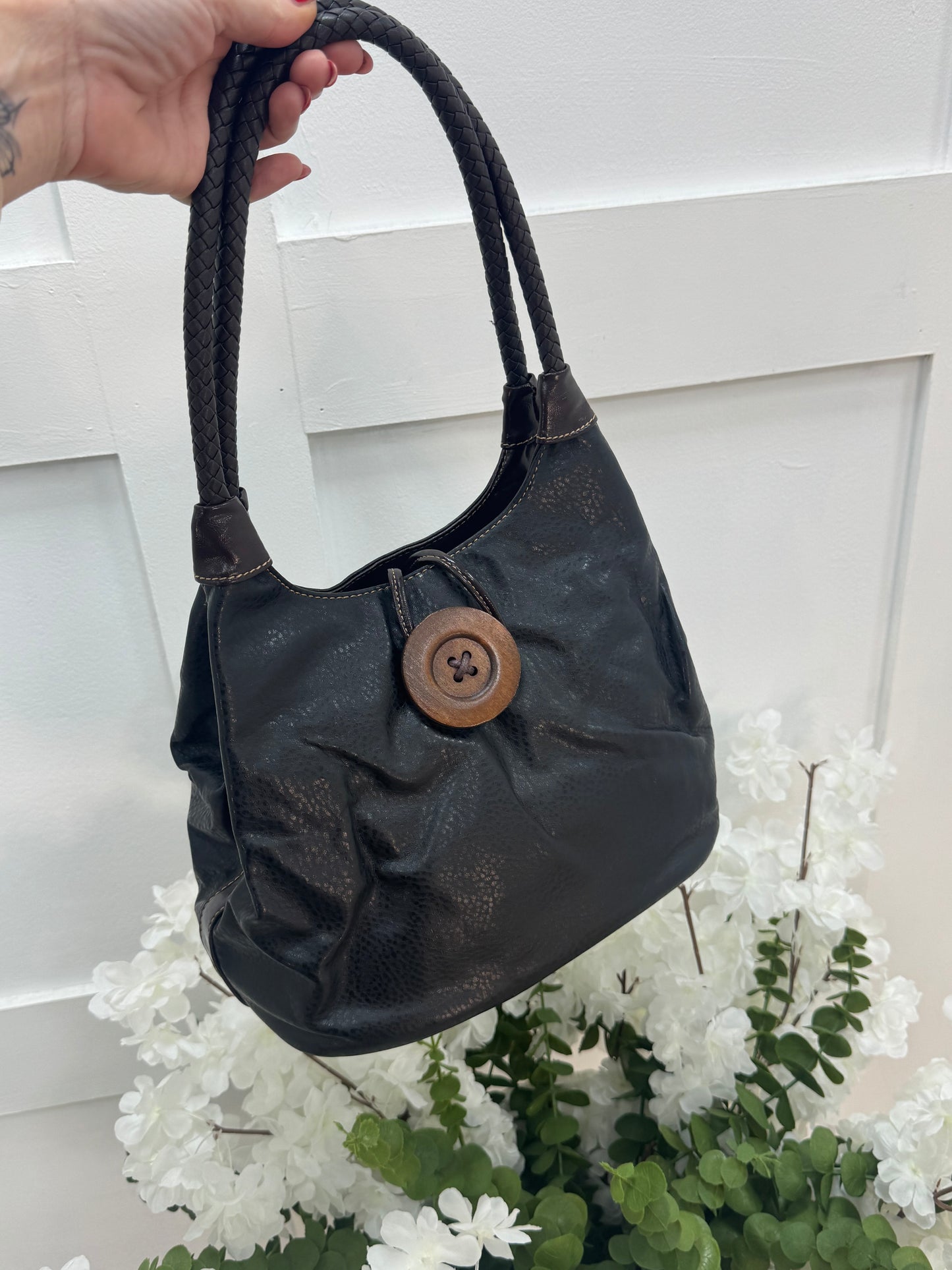 Pipa: Black slouchy big button shoulder bag.