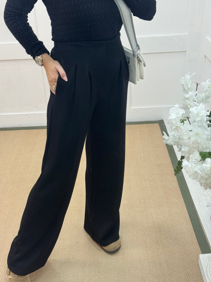 Tayla: Black high waisted pleated wide leg trousers. One size: 10-16