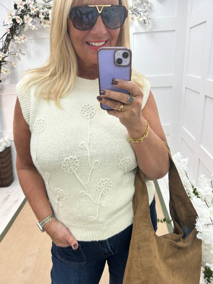 Larry: Cream sleeveless tank top with flower detail. One Sz: 12-18