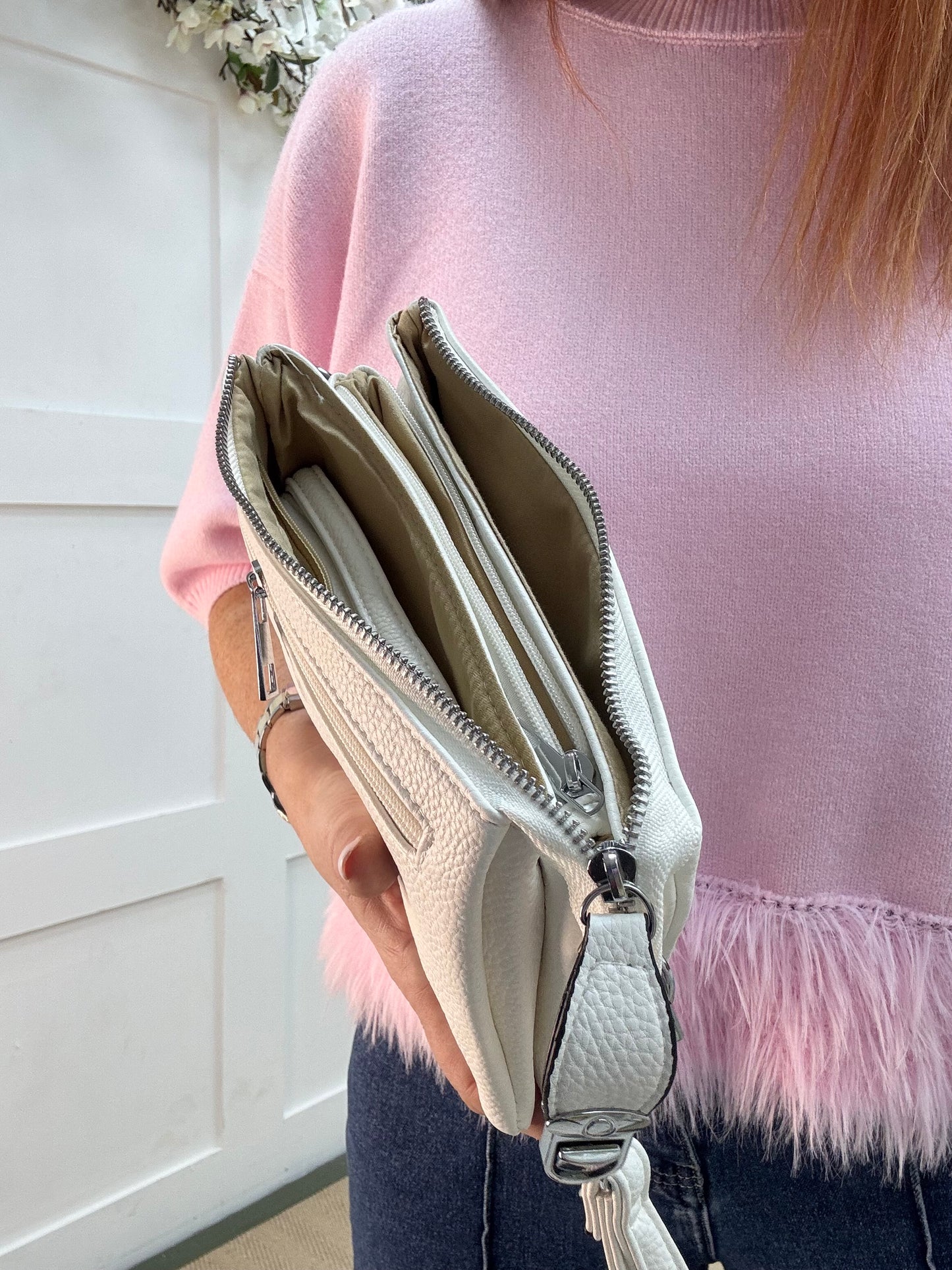 Britt: White three pocket crossbody bag.