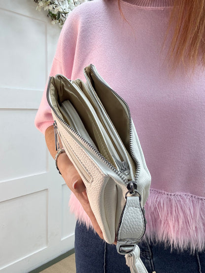 Britt: White three pocket crossbody bag.