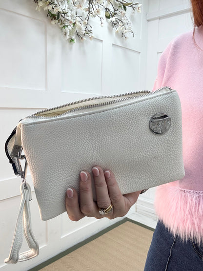 Britt: White three pocket crossbody bag.