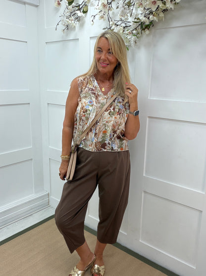 Flora: Sleeveless V neck ruffle front floral printed top. One Sz: 10- 16