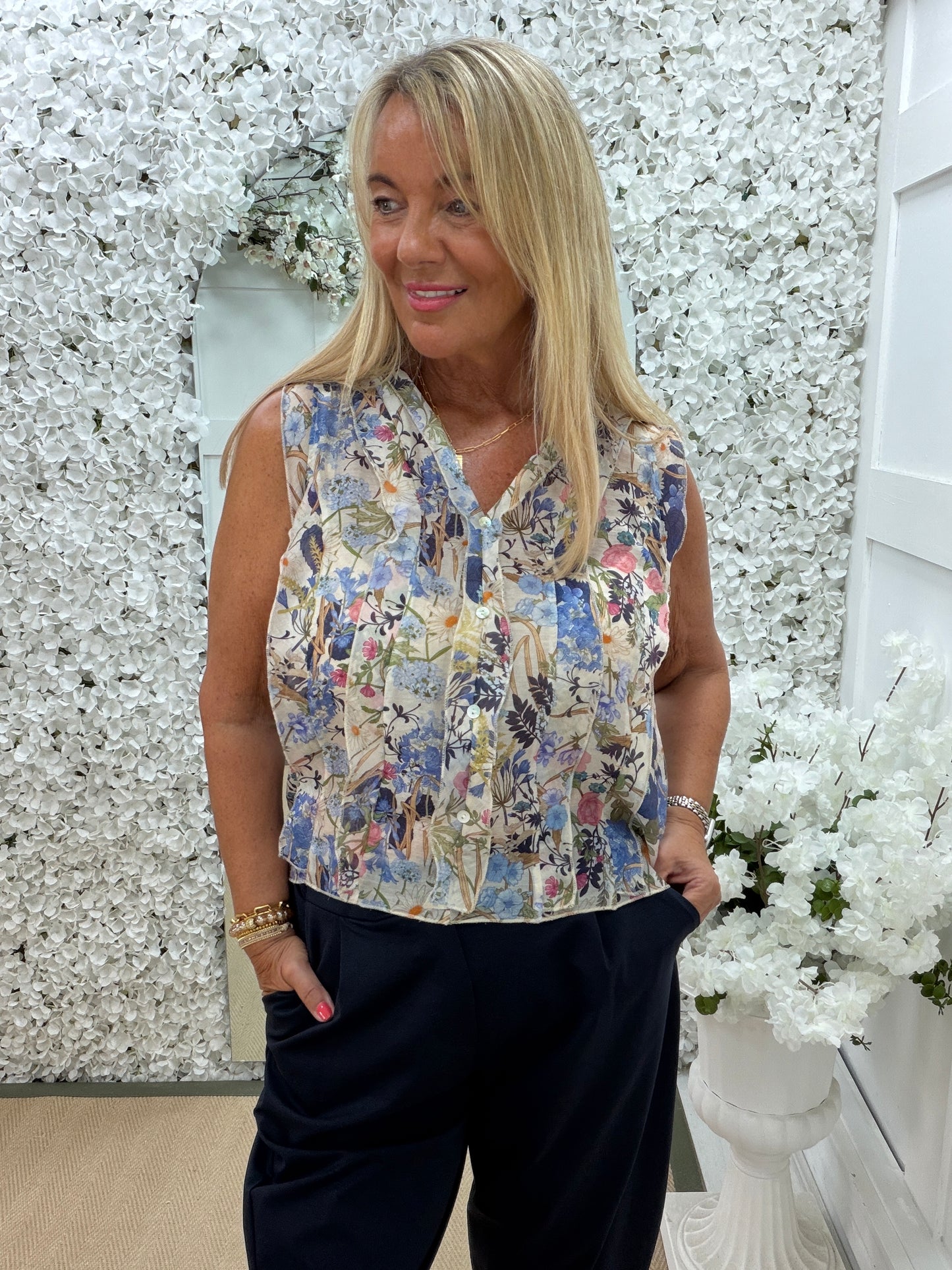 Flora: Sleeveless V neck ruffle front floral printed top. One Sz: 10- 16