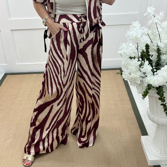 Aven: Burgundy zebra print wide leg trousers. One size: 10-16