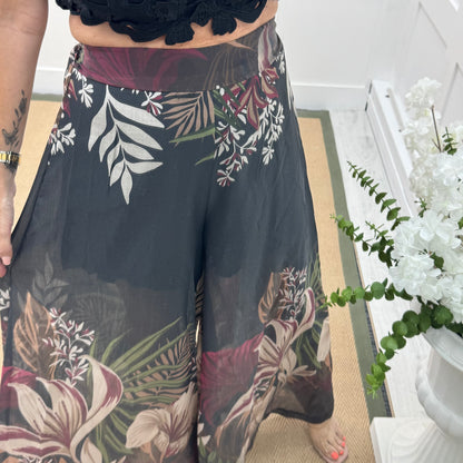 Lyra: Black tropical print wide leg sheer trousers. One size: 8-14