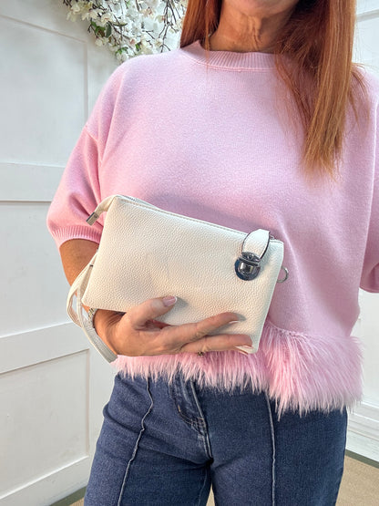 Britt: White three pocket crossbody bag.