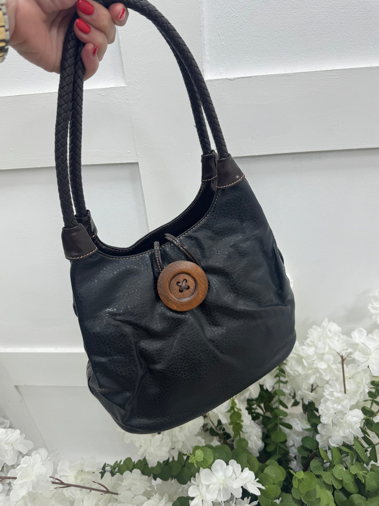 Pipa: Black slouchy big button shoulder bag.