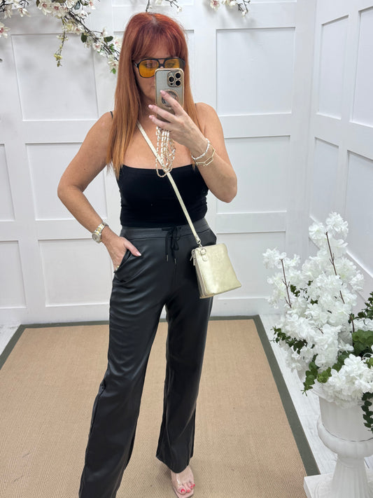 Geri: Black faux leather wide leg trousers.