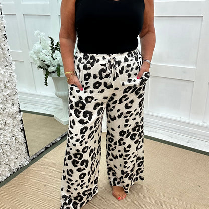 Dakota: White leopard print wide leg silky trousers. One size: 10-18