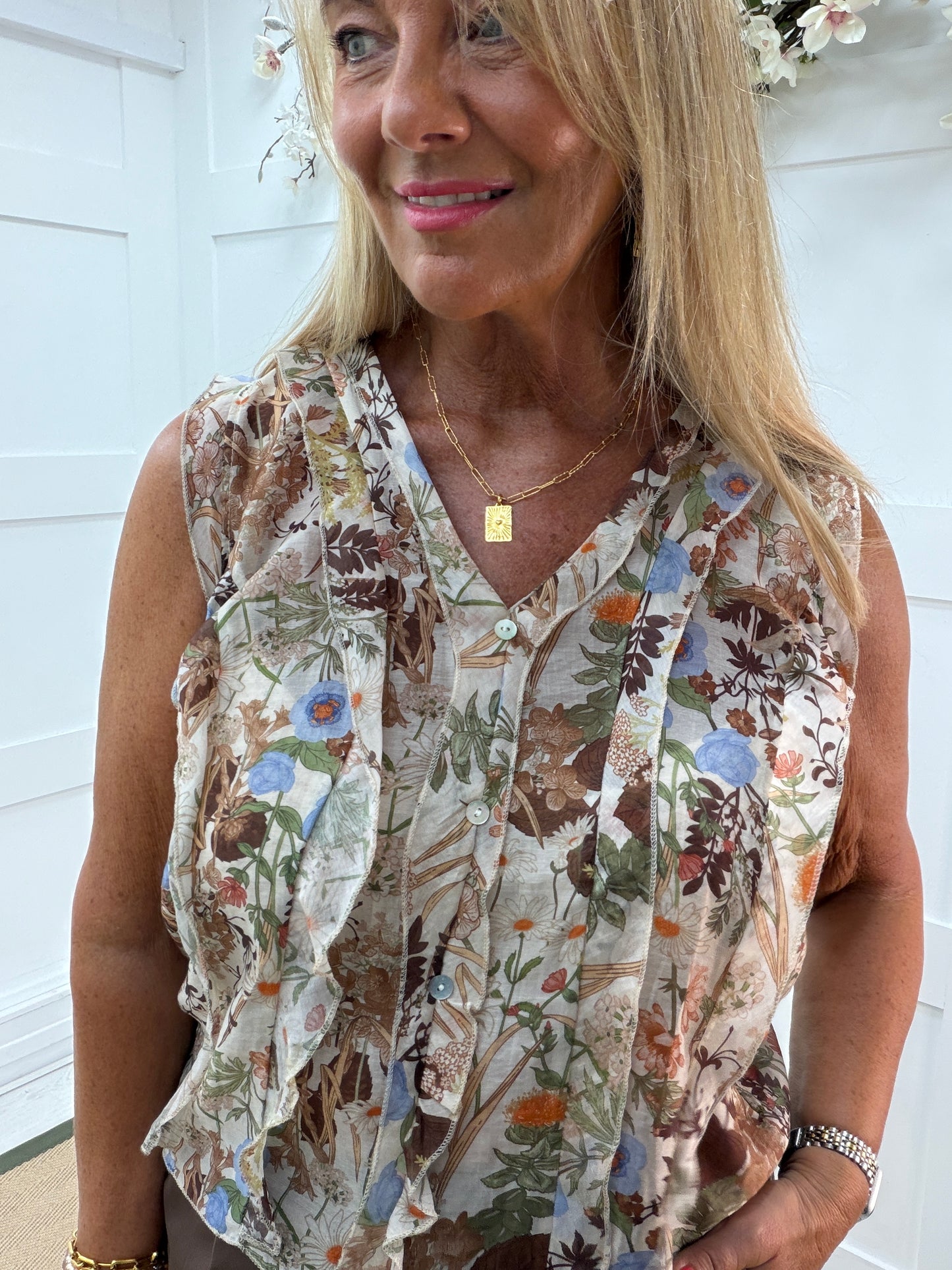 Flora: Sleeveless V neck ruffle front floral printed top. One Sz: 10- 16