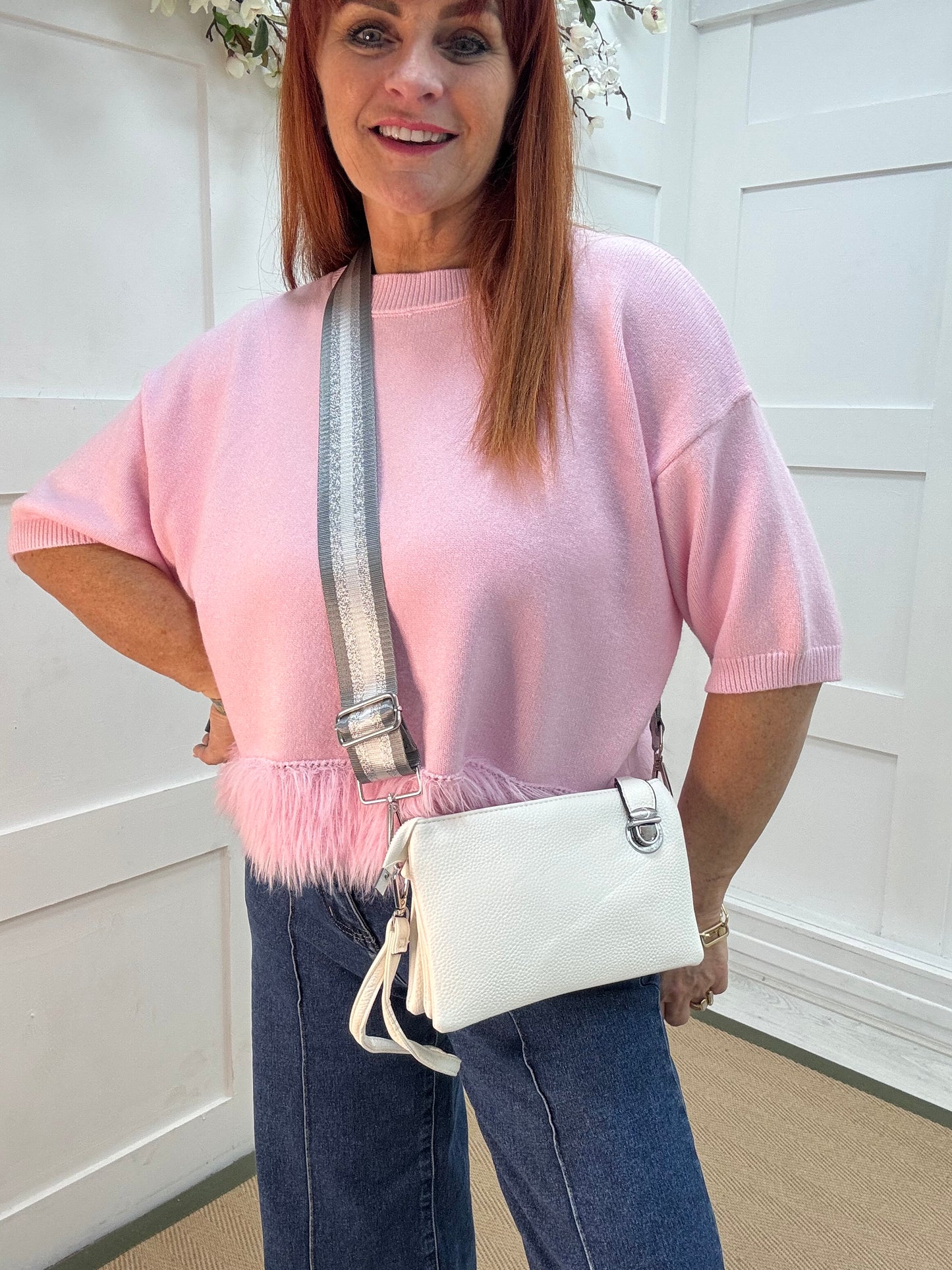 Britt: White three pocket crossbody bag.