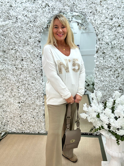 Cass: Cream V neck diamanté No5 knit top. One size: 14-20